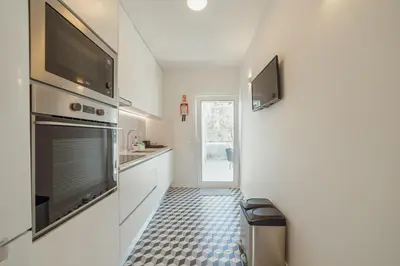 a kitchen with a television and a tiled floor at Porto Panoramic Views With Terrace by Vacationy in Porto