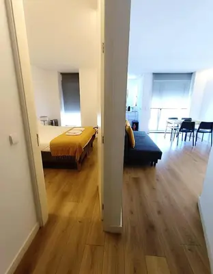 a bedroom with a bed and a table with a television at Camões Appartments in Porto