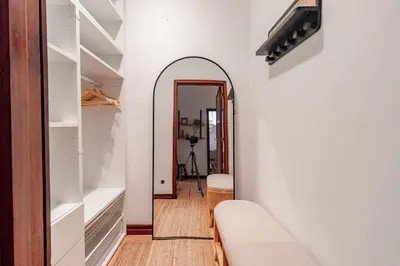 a hallway with a mirror and a white wall at Apartamento com terraço in Porto
