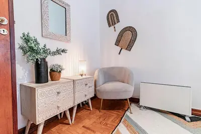 a living room with a chair and a dresser at Apartamento com terraço in Porto