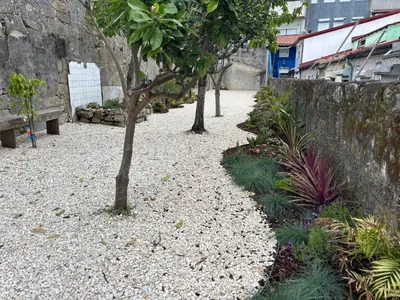 a gravel pathway with trees and a stone wall at Studio para 4 pessoas no Porto in Porto