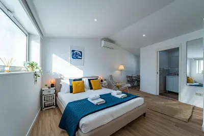 a bedroom with a large bed with yellow pillows at Oporto Nura Studio Downtown in Porto