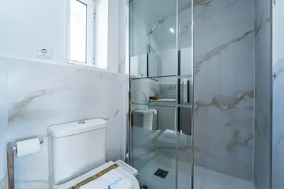 a bathroom with a toilet and a glass shower at Oporto Nura Studio Downtown in Porto