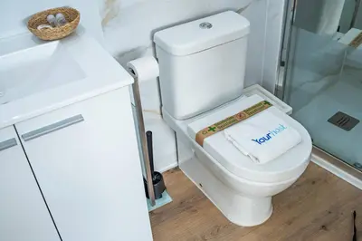 a bathroom with a white toilet and a sink at Oporto Nura Studio Downtown in Porto