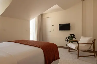 a bedroom with a bed and a chair and a tv at Vila Catarina Luxury Apartments in Porto
