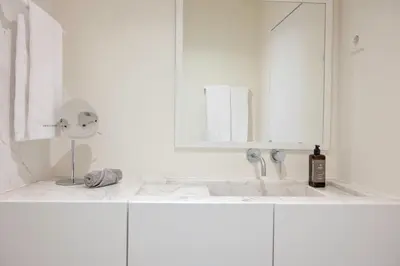 a white bathroom with a sink and a mirror at Vila Catarina Luxury Apartments in Porto