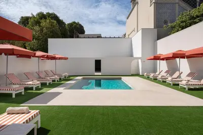 a pool with chairs and umbrellas on a lawn at Vila Catarina Luxury Apartments in Porto