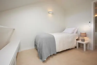 a white bedroom with a bed and a side table at Dux in Porto