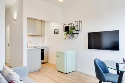 a kitchen and a living room with a table and a refrigerator at Rola Art Work Studio II by DA'HOME in Porto