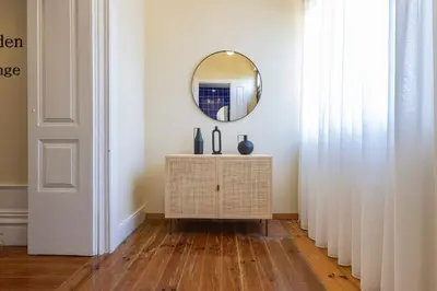 a living room with a mirror and a table at Guesthouse Bonjardim by LovelyStay in Porto