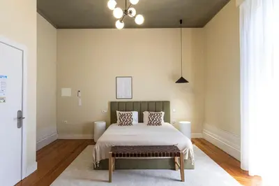 a bedroom with a bed and a chandelier at Guesthouse Bonjardim by LovelyStay in Porto