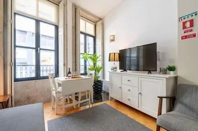 a living room with a television on a white dresser at Host Wise - Colourful Cozy Flat in Porto