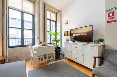a living room with a tv and a table and a couch at Host Wise - Colourful Cozy Flat in Porto