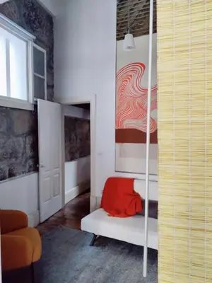 a living room with a bed and a chair at Central Stonehouse with terrace in Porto
