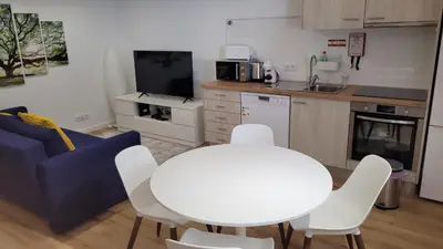 a kitchen with a white table and white chairs at Guest House CR5 in Porto