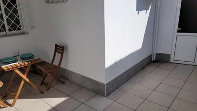 a table and chairs sitting next to a white wall at Guest House CR5 in Porto