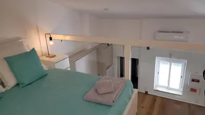 a bedroom with a bed with a green comforter at Guest House CR5 in Porto