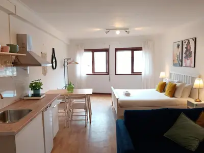 a kitchen and living room with a couch and a table at Travel and Live Poveiros in Porto