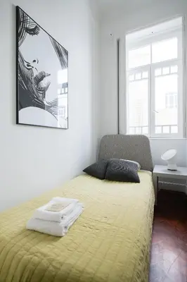 a bedroom with a bed with a yellow blanket at Baixa24 · City Center Private Sun Deck Apartment in Porto