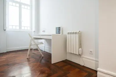 a white desk with a chair next to a radiator at Baixa24 · City Center Private Sun Deck Apartment in Porto