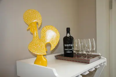 a table with a bottle of wine and a yellow duck statue at Toctoc Yellow in Porto