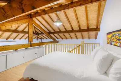 a bedroom with a white bed and wooden ceilings at Green Tiles House in Porto