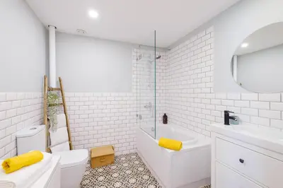a white bathroom with a tub and a toilet and a sink at Green Tiles House in Porto
