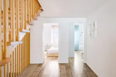 a white room with a bed and a staircase at Green Tiles House in Porto