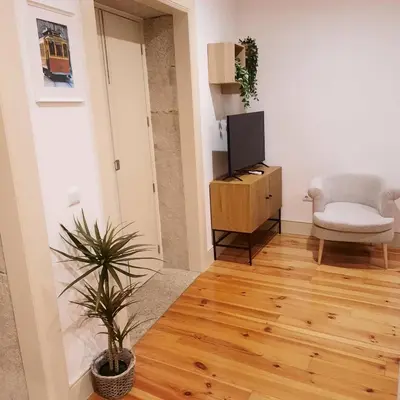 a living room with a tv and a chair at Premium Apartment Porto Downtown - Bonjardim in Porto