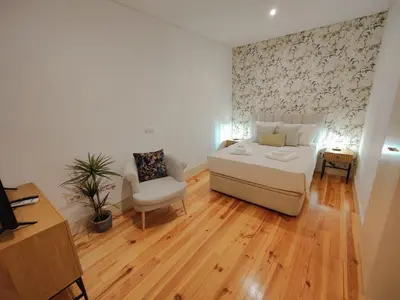 a bedroom with a bed and a chair in a room at Premium Apartment Porto Downtown - Bonjardim in Porto