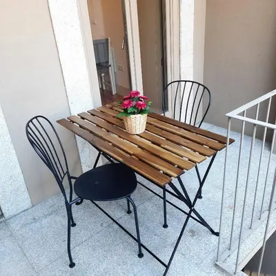 a wooden table with two chairs and a potted plant on it at Premium Apartment Porto Downtown - Bonjardim in Porto