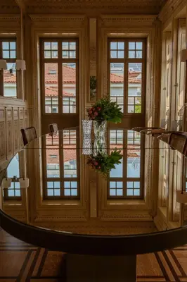 a dining room with a glass table and windows at Palacete Severo in Porto