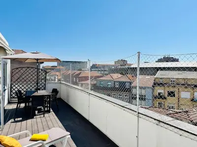 a balcony with a table and an umbrella at Premium Quental House - T3 Renovado com magnifico Terraço in Porto