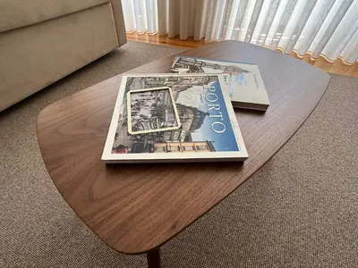 a coffee table with a book and a magazine on it at Lit Apartments - CLÉRIGOS in Porto