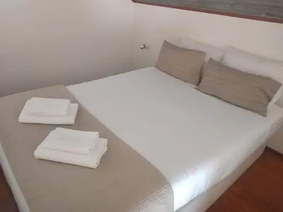 a large white bed with two pillows on it at Porto Studio in Porto