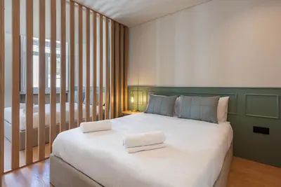 a bedroom with a large bed with two towels on it at Doispontozero Alegria Green in Porto