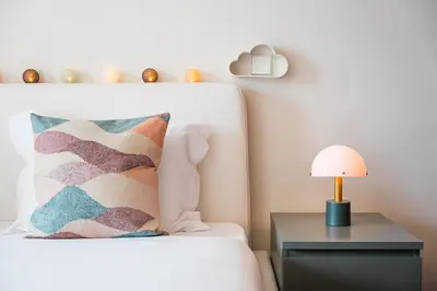 a bed with a pillow and a lamp on a night stand at GuestReady - Teddy Jazz in Porto