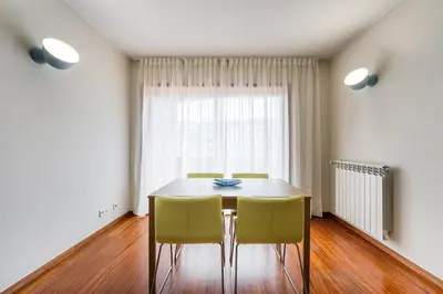 a dining room table with chairs and a window at GuestReady - Teddy Jazz in Porto