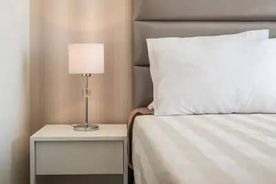 a bed with a lamp on a nightstand next to a bed at GuestReady - Mushroom in Porto