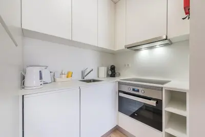 a kitchen with white cabinets and a stove at GuestReady - Mushroom in Porto