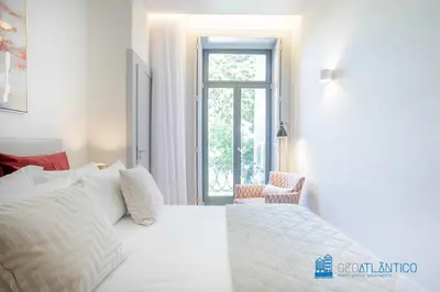 a bedroom with a bed with white sheets and pillows at Boavista Central Garden & Terrace in Porto