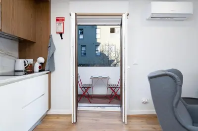 a kitchen with a door open to a balcony with a table at GuestReady - Stylish stay with balcony in Gaia in Vila Nova de Gaia