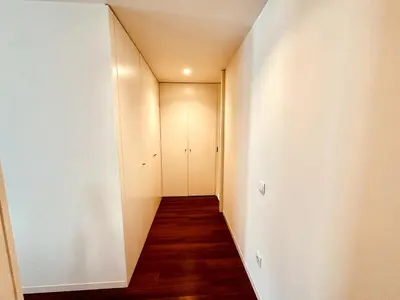 a hallway with white walls and wood floors and a door at Bombarda 250 E in Porto