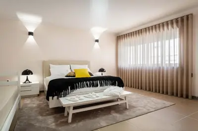 a white bedroom with a bed and a window at Pinheiro Cardoso in Porto