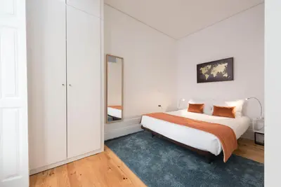 a white bedroom with a bed and a mirror at Apartment Alegria Street by Sweet Porto - Free Parking in Porto