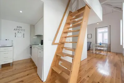 a wooden staircase in a kitchen and a living room at Apartment Alegria Street by Sweet Porto - Free Parking in Porto