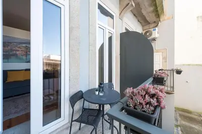 a balcony with a table and chairs and a window at Apartment Alegria Street by Sweet Porto - Free Parking in Porto
