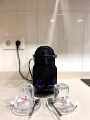 a black coffee maker with two glasses on a counter at Douro Residence Porto Gaia in Vila Nova de Gaia