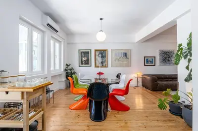 a living room with a table and colorful chairs at St Catarina 555 Apartment in Porto