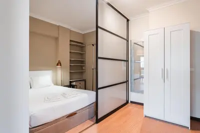 a bedroom with a white bed and a sliding glass door at GuestReady - Central Porto Gem in Porto